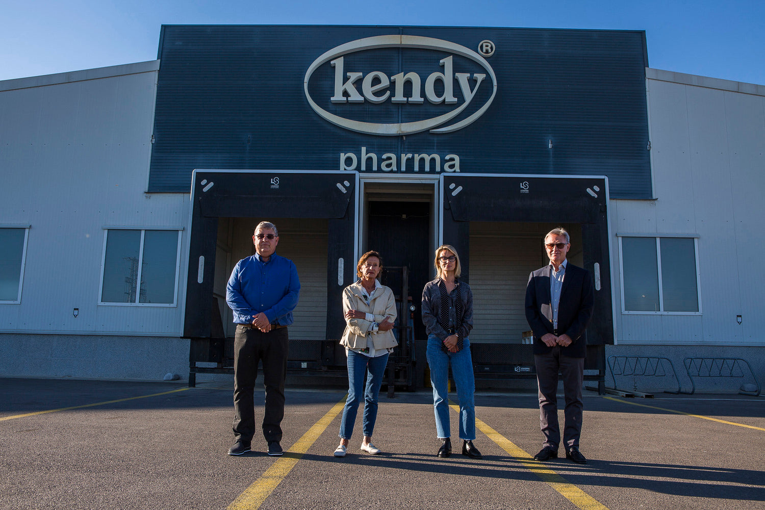 Четирима души от екипа на Kendy Pharma пред производствената сграда с логото kendy pharma