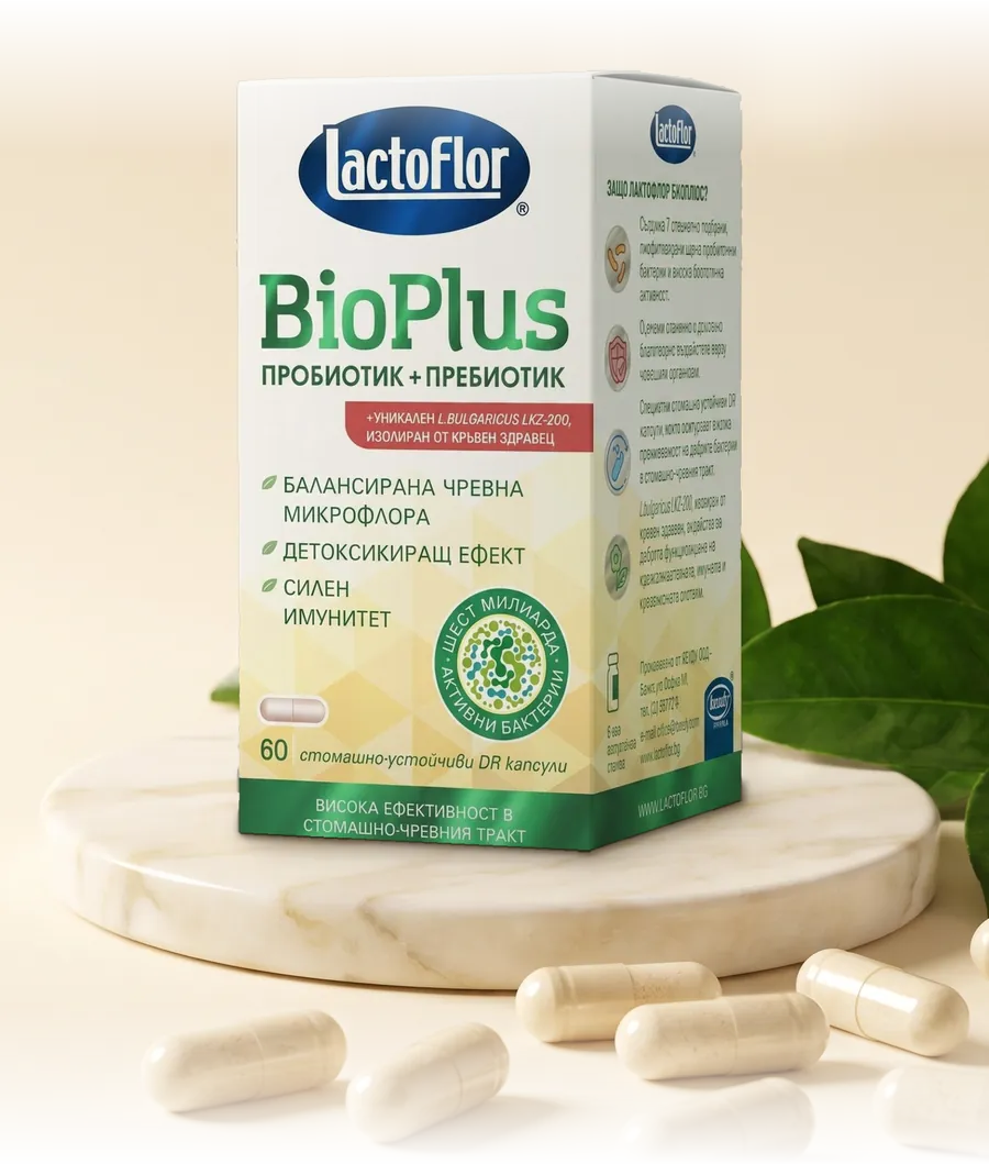Lactoflor BioPlus капсули върху мраморна плоча, заобиколена от зелени листа и пробиотични капсули